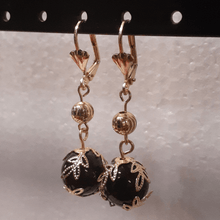 Cargar imagen en el visor de la galería, Hanging black ball surrounded by leaves