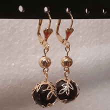 Cargar imagen en el visor de la galería, Hanging black ball surrounded by leaves